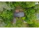 Aerial view of a home enveloped by lush trees, featuring a wooden deck, grassy yard, and mature landscaping at 4052 Shawnee Ne Ln, Brookhaven, GA 30319