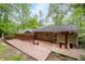 Backyard with a wooden deck and a ramp, surrounded by lush trees and foliage, offering serene outdoor living at 4052 Shawnee Ne Ln, Brookhaven, GA 30319