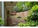 Backyard with a wooden deck, stone pathway, lush plants, and wooden fence, creating an enchanting outdoor oasis at 4052 Shawnee Ne Ln, Brookhaven, GA 30319