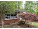Close up of red brick home featuring mature landscaping, including a red Japanese maple tree at 4052 Shawnee Ne Ln, Brookhaven, GA 30319
