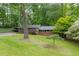 Charming home with a brick facade, lush green lawn, and mature trees offering a serene and inviting curb appeal at 4052 Shawnee Ne Ln, Brookhaven, GA 30319
