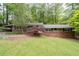 Charming single-story brick home with a well-manicured lawn and mature trees providing shade at 4052 Shawnee Ne Ln, Brookhaven, GA 30319