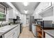 Galley kitchen with white cabinetry, stainless steel appliances, and a bright window over the sink at 4052 Shawnee Ne Ln, Brookhaven, GA 30319