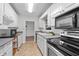 Galley kitchen featuring white cabinets, gray counters, and modern appliances at 4052 Shawnee Ne Ln, Brookhaven, GA 30319