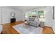 Comfortable living room with hardwood floors, gray sofa, and large windows with natural light at 4052 Shawnee Ne Ln, Brookhaven, GA 30319