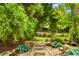 Landscaped backyard with stone walkway and lush greenery provides a private oasis at 4779 Moon Hollow Ct, Buford, GA 30519