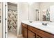 Bathroom featuring a double sink vanity, framed mirrors, and a floral curtain in the shower at 4779 Moon Hollow Ct, Buford, GA 30519