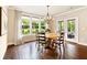 Cozy dining area featuring a round wooden table, chandelier lighting, and large windows overlooking the landscaped yard at 4779 Moon Hollow Ct, Buford, GA 30519