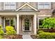 Inviting front porch with stone tiles, white pillars, and landscaped garden at 4779 Moon Hollow Ct, Buford, GA 30519