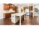 Well-lit kitchen with dark wood cabinets, stainless steel appliances, and an island with barstool seating at 4779 Moon Hollow Ct, Buford, GA 30519