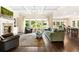 Bright living room boasts hardwood floors, coffered ceilings, fireplace, and many large windows with views of the outdoor greenery at 4779 Moon Hollow Ct, Buford, GA 30519