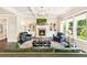Spacious living room with fireplace, built-in bookshelves, and a large window overlooking the green backyard at 4779 Moon Hollow Ct, Buford, GA 30519