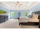 Well-lit main bedroom offers natural light, neutral carpet, and elegant dark wood furniture at 4779 Moon Hollow Ct, Buford, GA 30519