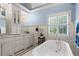 Bright bathroom features a clawfoot tub, chandelier, and white cabinets at 6330 Spinnaker Ln, Alpharetta, GA 30005