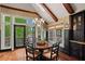 Bright breakfast nook with large windows and French doors, complemented by hardwood floors and built-in cabinetry at 6330 Spinnaker Ln, Alpharetta, GA 30005