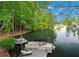 Picturesque view of the lake from the water featuring a private dock with a pontoon boat at 6330 Spinnaker Ln, Alpharetta, GA 30005