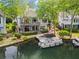 Waterfront home with a dock and a boat, featuring multiple decks and lush landscaping along the shoreline at 6330 Spinnaker Ln, Alpharetta, GA 30005