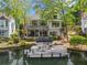 Stunning waterfront home with lush landscaping and a boat docked on the calm waters at 6330 Spinnaker Ln, Alpharetta, GA 30005