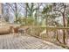Wooden deck with outdoor seating surrounded by lush greenery and trees at 1205 Druid Knoll Ne Dr, Brookhaven, GA 30319