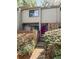 Charming townhome featuring a stone facade, a vibrant red door, and beautifully landscaped entryway at 1205 Druid Knoll Ne Dr, Brookhaven, GA 30319