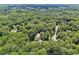 Expansive aerial shot showcasing a home surrounded by verdant trees and a winding neighborhood street at 211 Black Kettle Ln, Johns Creek, GA 30022