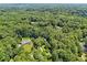 Scenic aerial view highlighting a home nestled amidst a vast expanse of mature trees and greenery at 211 Black Kettle Ln, Johns Creek, GA 30022