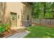 Well-maintained backyard with a small lawn and decorative landscaping adjacent to the home at 211 Black Kettle Ln, Johns Creek, GA 30022
