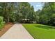 Long driveway leading to a home with a well-manicured front yard at 211 Black Kettle Ln, Johns Creek, GA 30022