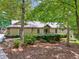Charming home with stone accents, wood siding, and lush landscaping in a serene, wooded setting at 211 Black Kettle Ln, Johns Creek, GA 30022