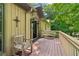 Inviting front porch with seating, stone accents, wood siding, and dual outdoor lights at 211 Black Kettle Ln, Johns Creek, GA 30022