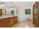 A large bathroom features a double vanity, soaking tub, and walk-in shower at 211 Black Kettle Ln, Johns Creek, GA 30022