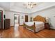 Bright main bedroom features wood floors, a tray ceiling, and an ornate headboard at 211 Black Kettle Ln, Johns Creek, GA 30022