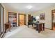 Neutral toned office with a large desk, built-in bookcase, and lots of natural light at 211 Black Kettle Ln, Johns Creek, GA 30022