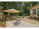 Outdoor patio with stone pavers, landscaping, and an umbrella table for enjoying the backyard at 211 Black Kettle Ln, Johns Creek, GA 30022