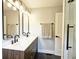 Modern bathroom featuring a double vanity, elegant mirrors, and a glass-enclosed shower with black fixtures at 217 Penelope Nw Dr, Atlanta, GA 30314