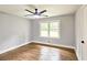 Bright, empty bedroom with hardwood floors, a ceiling fan, and a large window at 217 Penelope Nw Dr, Atlanta, GA 30314