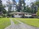 Charming single story home with a well-manicured lawn, mature trees, and a driveway at 217 Penelope Nw Dr, Atlanta, GA 30314