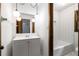 Bathroom featuring globe lighting, a tiled tub, and white vanity at 4444 Bending River Sw Trl, Lilburn, GA 30047