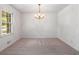 Dining room featuring neutral carpet, a window, and a classic chandelier at 4444 Bending River Sw Trl, Lilburn, GA 30047