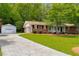 Charming exterior with a well-manicured lawn, brick accents, and a detached garage at 4444 Bending River Sw Trl, Lilburn, GA 30047