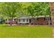 Charming single-story brick home with a well-maintained lawn and mature trees at 4444 Bending River Sw Trl, Lilburn, GA 30047
