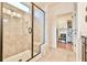 Bathroom features a glass-enclosed shower, tiled walls, and a doorway to the walk-in closet at 5641 Tisbury Ct, Hoschton, GA 30548