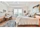 Light-filled bedroom with tray ceiling features a sitting area and large window with shutters at 5641 Tisbury Ct, Hoschton, GA 30548