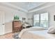 Bright bedroom with tray ceiling features a sitting area and a window with plantation shutters at 5641 Tisbury Ct, Hoschton, GA 30548