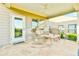 Cozy covered patio with comfortable seating, ceiling fan, and decorative stone flooring at 5641 Tisbury Ct, Hoschton, GA 30548