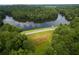 Scenic aerial view of a lakefront property surrounded by lush greenery and mature trees at 710 Glen Royal Dr, Roswell, GA 30076