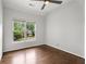 Bright bedroom with hardwood floors, ceiling fan, and view of a charming neighborhood at 710 Glen Royal Dr, Roswell, GA 30076