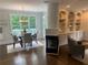 Dining area with modern light fixture, fireplace and built-in cabinets near a sunny deck at 710 Glen Royal Dr, Roswell, GA 30076