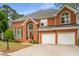 Attractive brick home featuring a manicured lawn, arched windows, and a convenient two-car garage at 710 Glen Royal Dr, Roswell, GA 30076