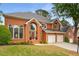 Beautiful brick home featuring a well-manicured lawn, arched windows, and a two-car garage at 710 Glen Royal Dr, Roswell, GA 30076